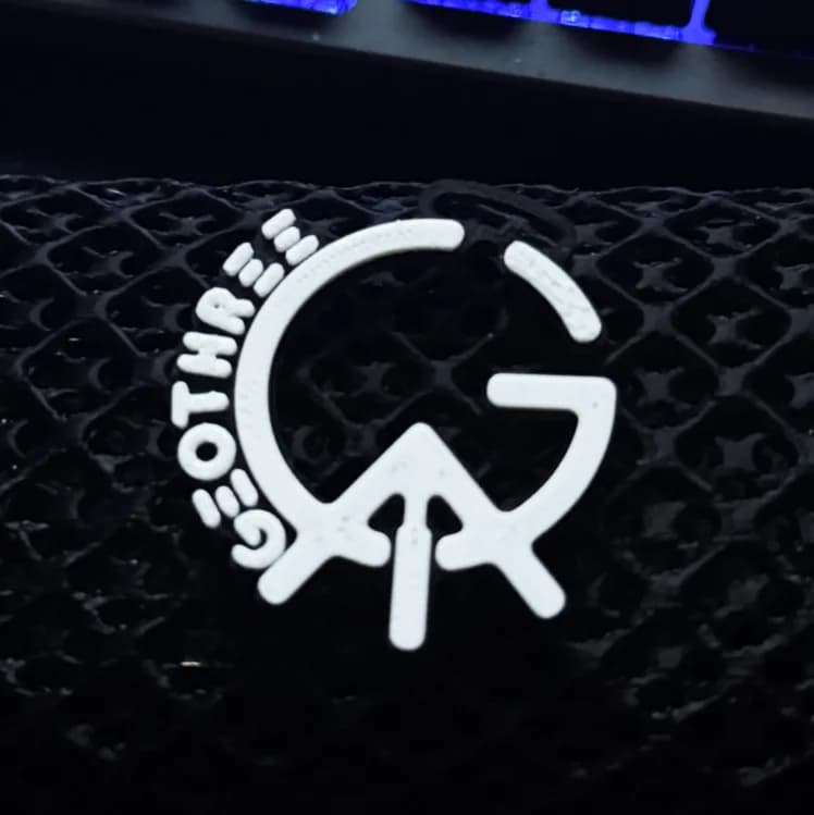 Fehér GeoThree logós kiegészítő fekete rácsszerkezetű felületen